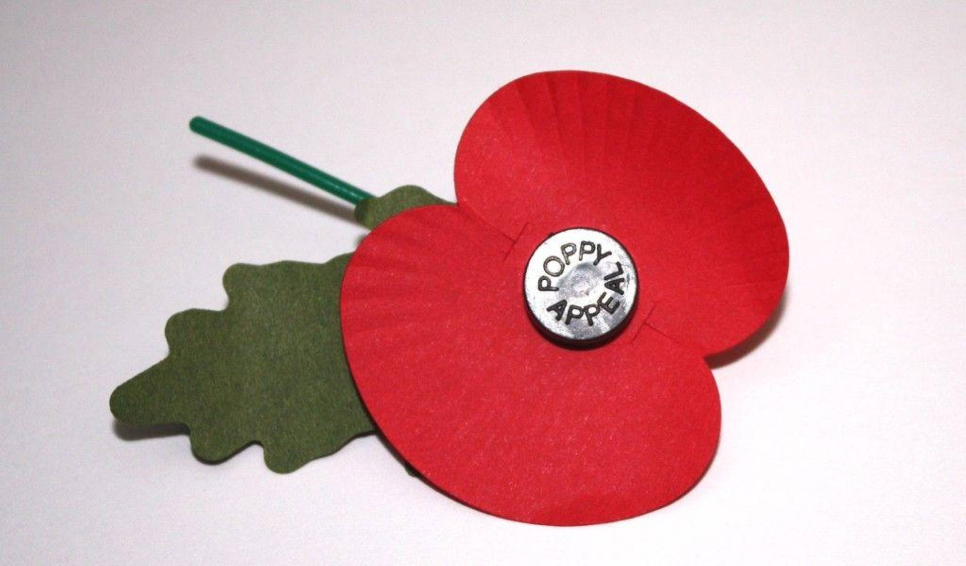 紅色紙罌粟花，配有綠色葉子和「Poppy Appeal」鈕扣，用於紀念日。