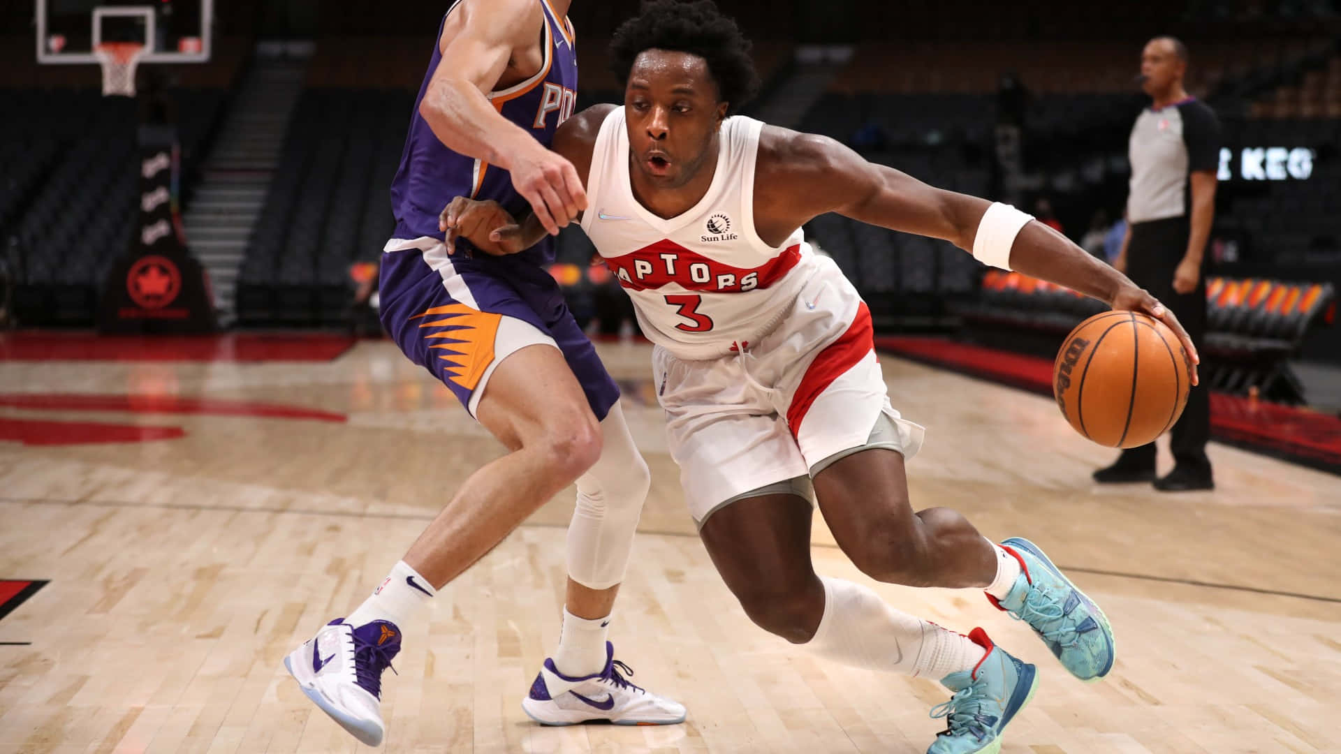 多倫多速龍球員在NBA比賽中運球越過鳳凰城太陽防守球員。