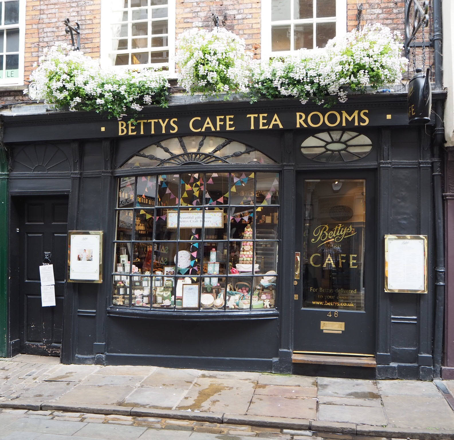 Betty's Cafe Tea Rooms 的店面，透過窗戶可以看到花箱和色彩繽紛的彩旗。