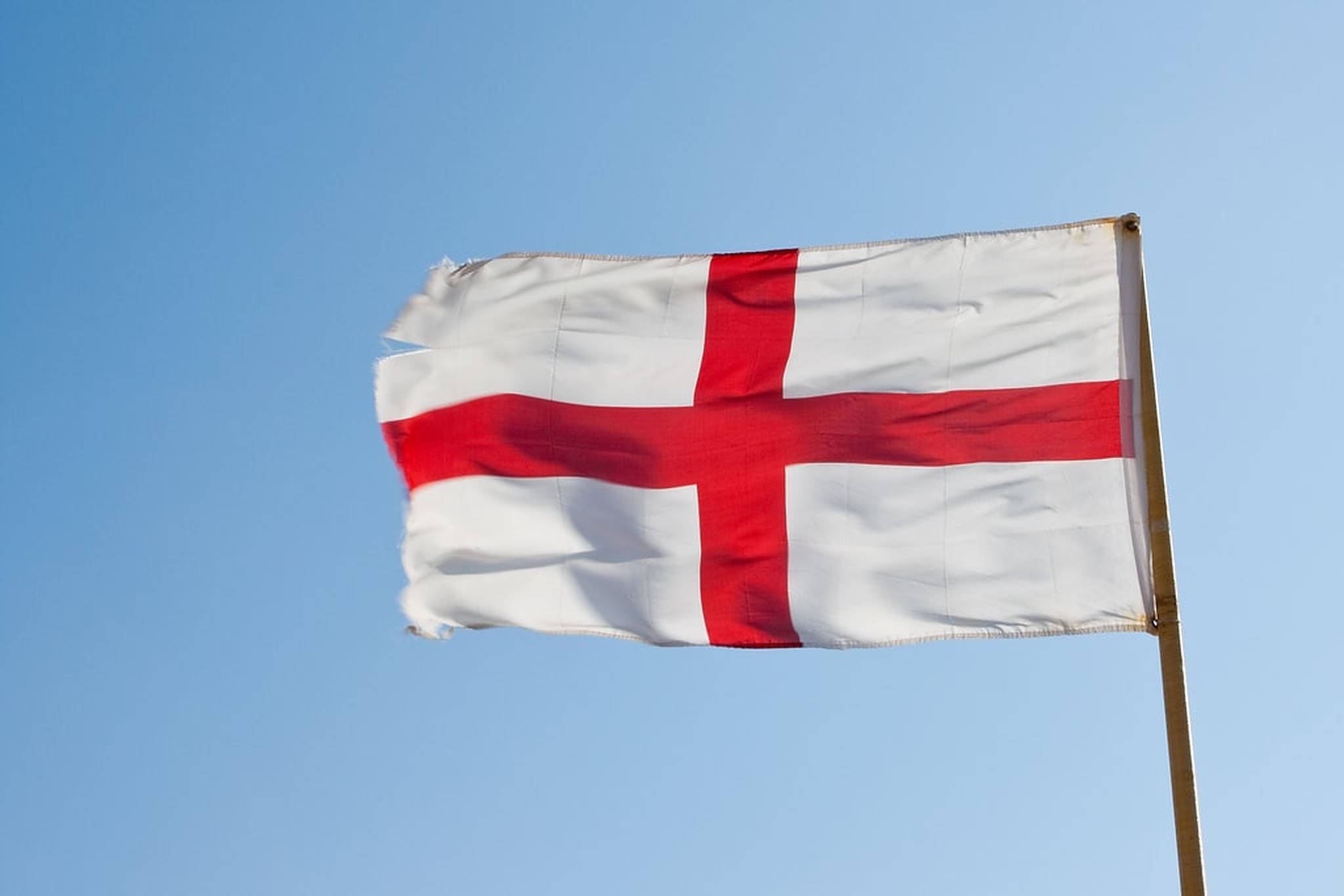 英格蘭國旗聖喬治十字 壁紙 — 英格蘭的聖佐治十字旗在晴朗的日子裏，在清澈的藍天下自豪地飄揚。