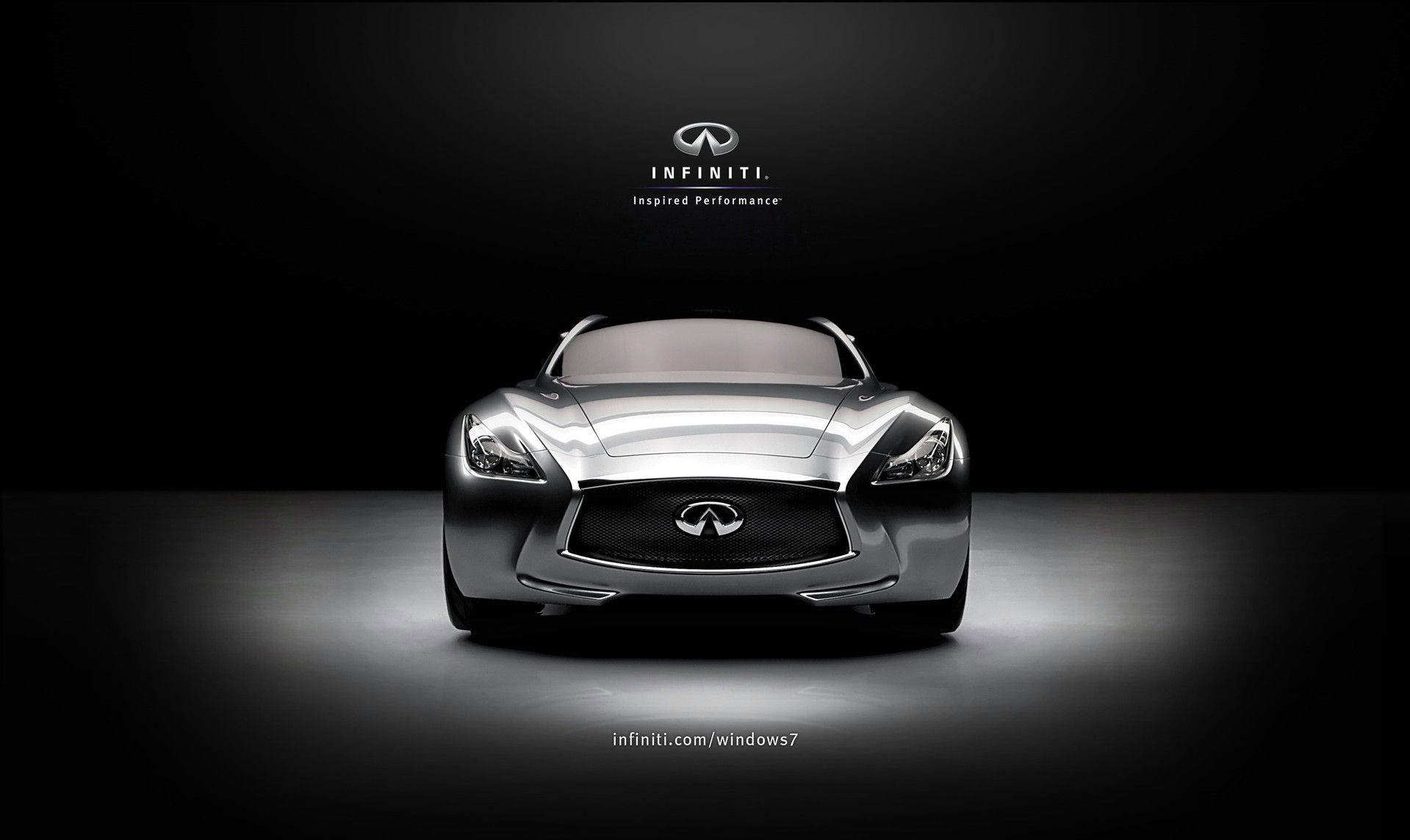 英菲尼迪Essence 壁紙 — 一輛時尚的銀色 Infiniti 概念車在攝影棚燈光下發光，黑色背景上方有品牌標誌。