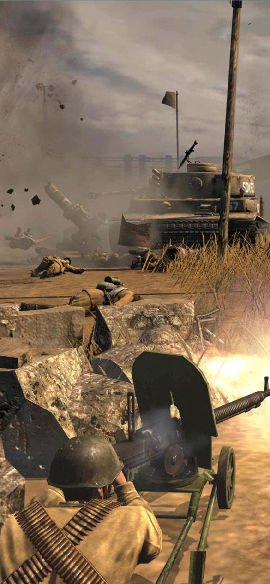 《英雄連隊2》壯烈戰場畫面於 iPhone XS 展現 壁紙 — 士兵操作機槍，爆炸和坦克戰在戰火摧殘的田野上肆虐，天空陰沉。
