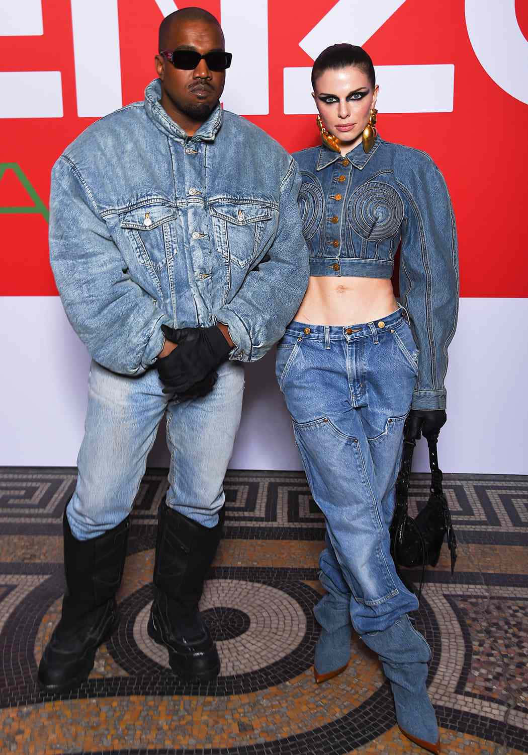 茱莉亞·福克斯身穿時尚服裝光彩照人 壁紙 — Kanye West 和 Bella Hadid 穿著相配的牛仔服裝，在鮮明的紅白品牌背景前擺姿勢。