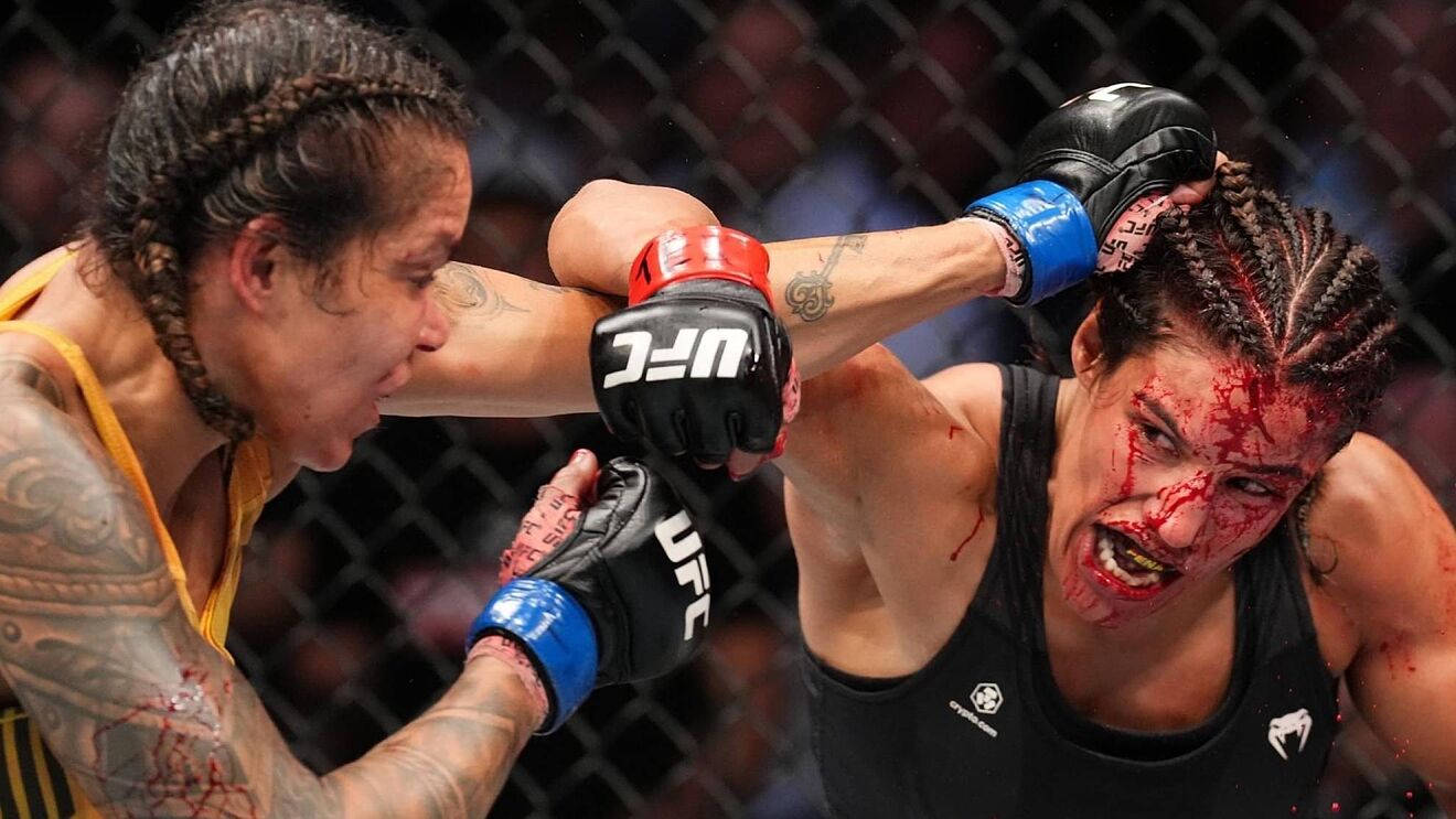茱莉安娜·佩納在激烈的UFC比賽中 壁紙 — 兩名女性MMA拳手在血腥的籠鬥中交鋒，鮮血濺在臉部和手套上。