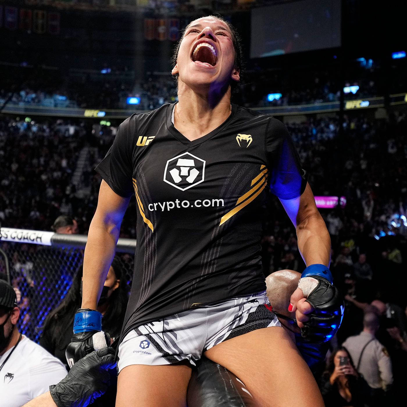 茱莉安娜·佩納高聲歡呼 壁紙 — 一名女性MMA拳手在八角籠內勝利吶喊，身後是咆哮的人群。
