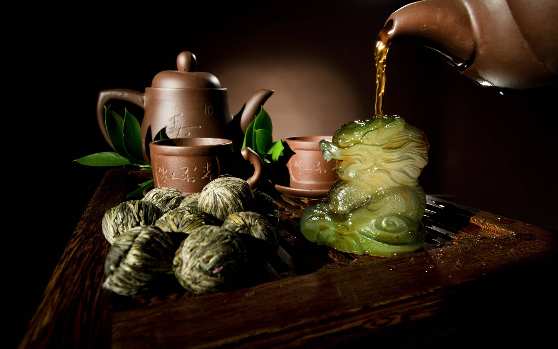 金色茶倒在翡翠龍公仔上，旁邊有茶球和陶瓷杯。
