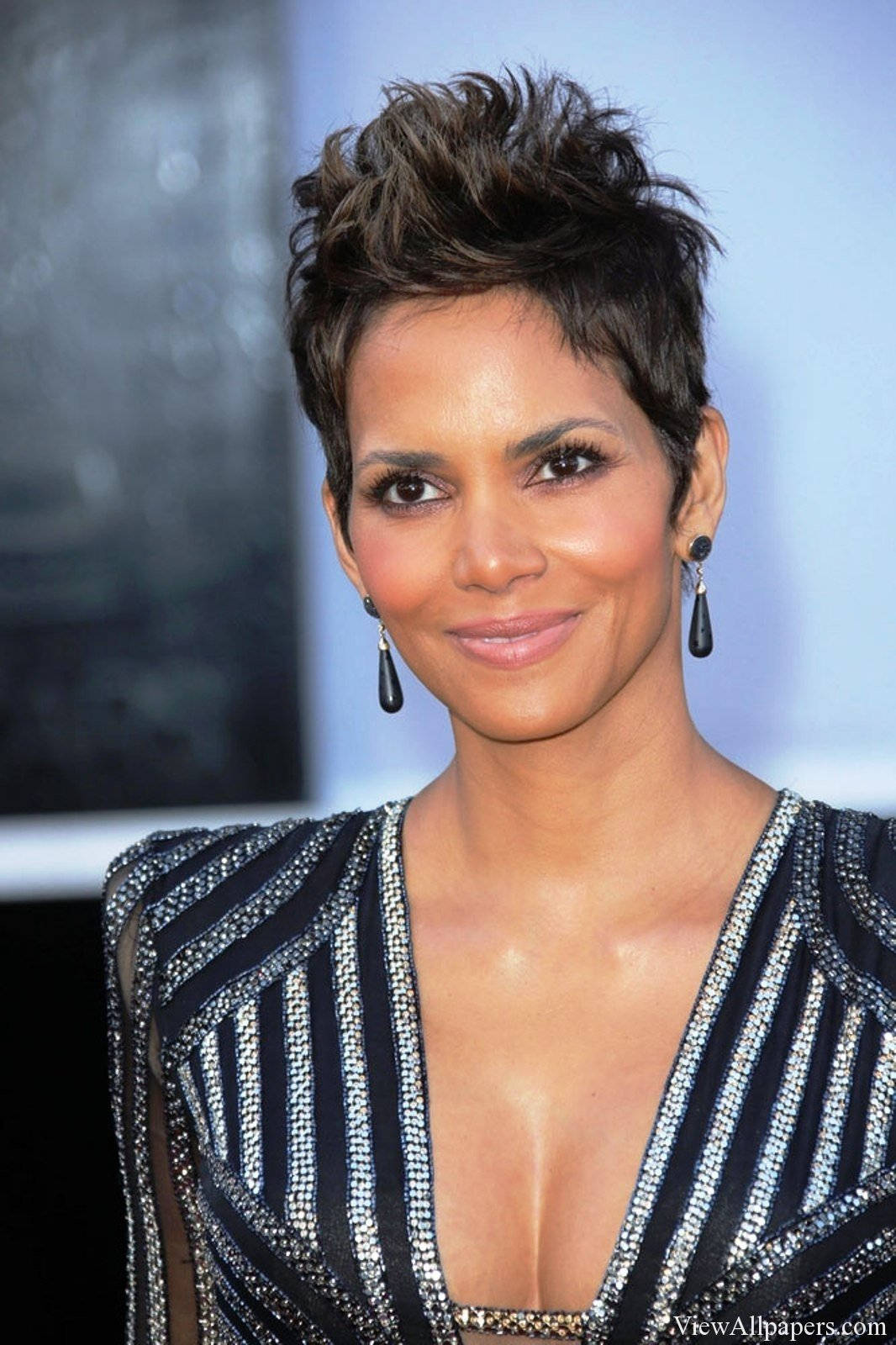 Short-Haired Halle Berry 壁紙 — 荷莉·貝瑞自信地微笑，身穿閃亮的黑銀條紋連衣裙，搭配大膽的耳環。