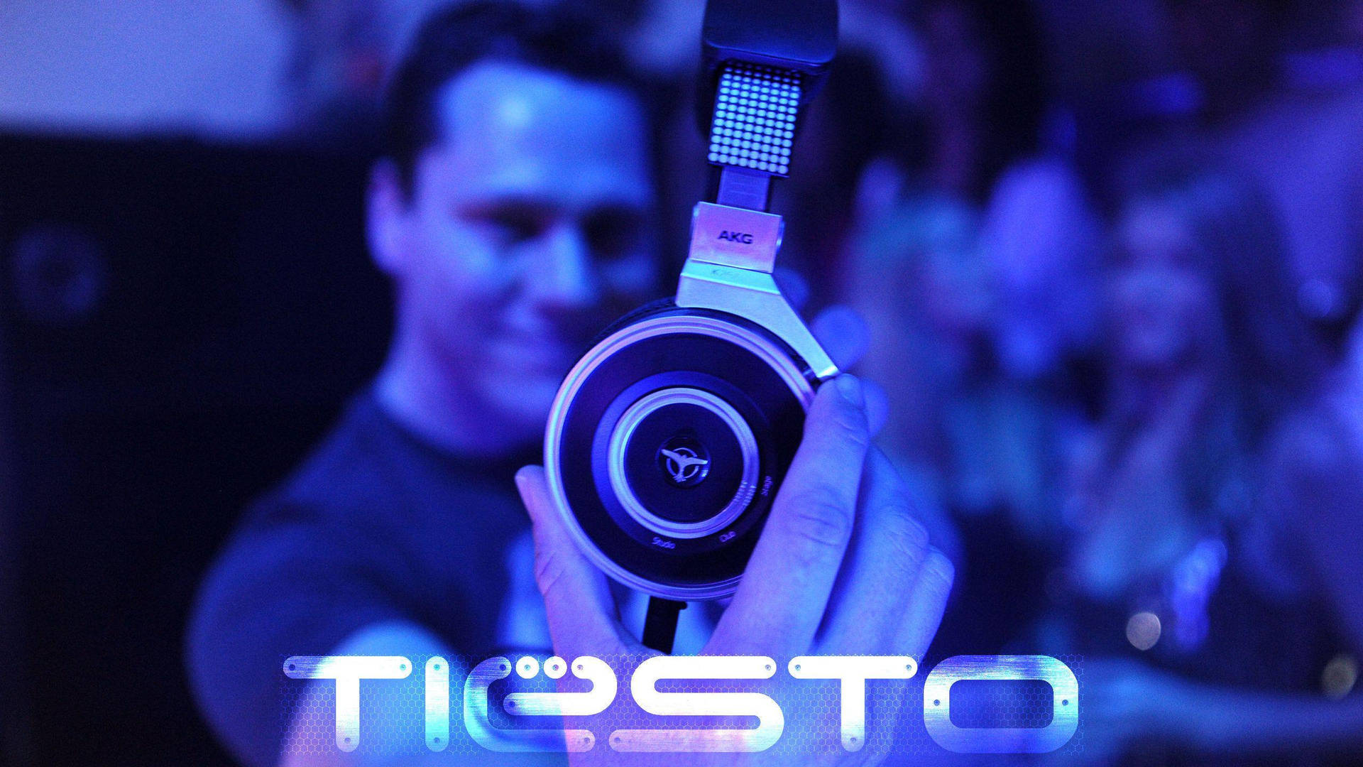 DJ Tiesto在音樂會上舉起發光的AKG耳機。