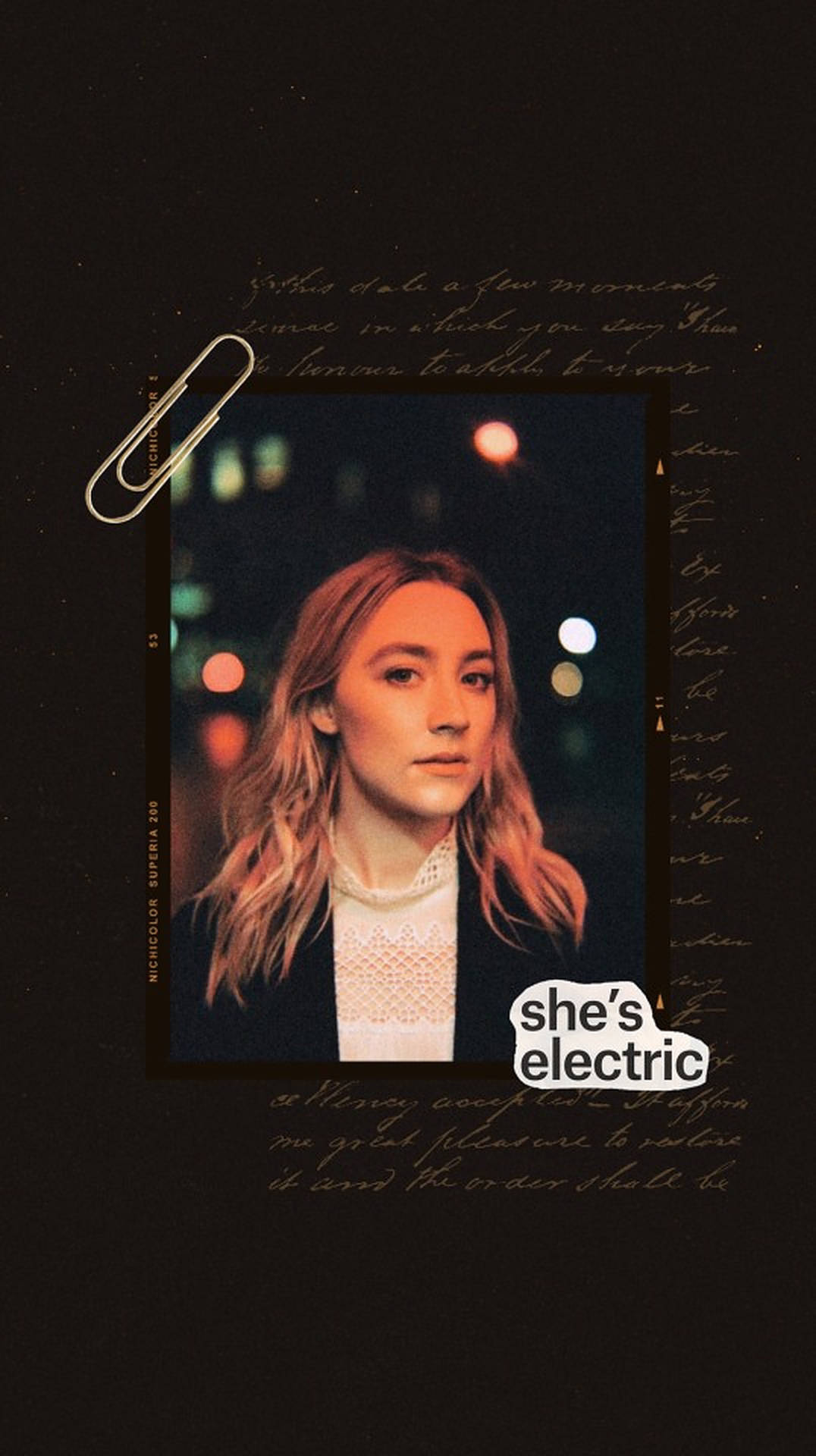 女性肖像，帶有'she's electric'文字，背景是夜間模糊的城市燈光。
