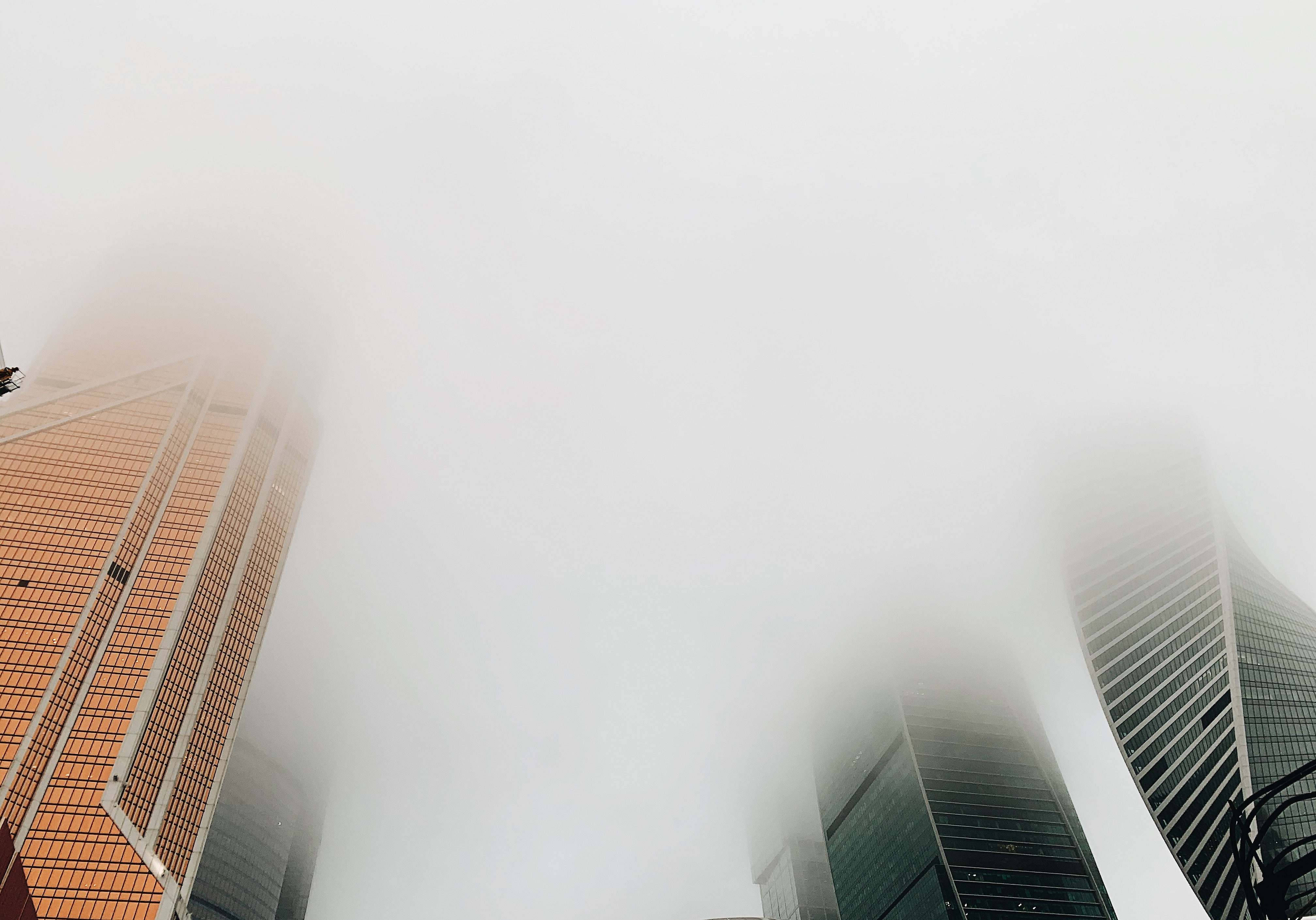 莫斯科俄羅斯摩天大樓霧氣 壁紙 — 高聳入雲的摩天大樓穿透濃霧，在色調柔和的迷霧都市峽谷中若隱若現。