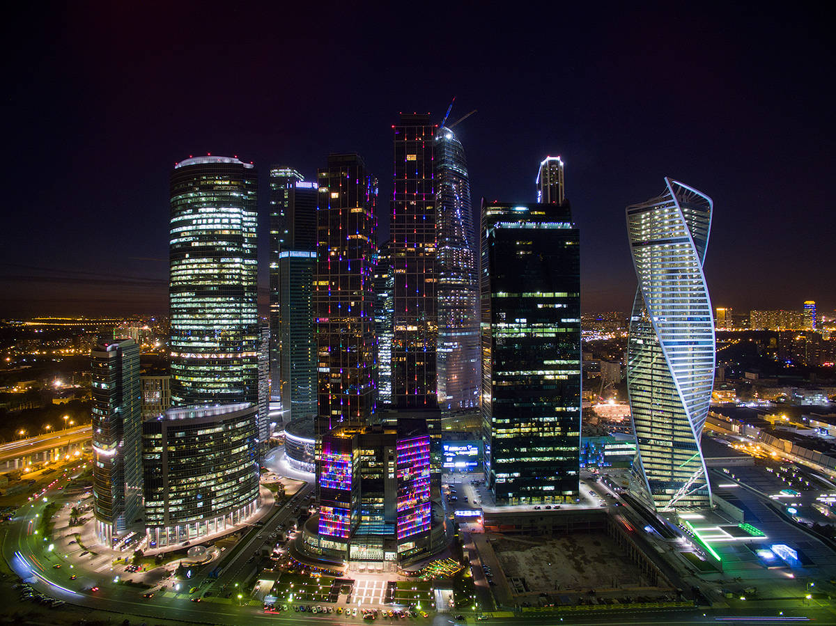 莫斯科摩天大樓霓虹夜景 壁紙 — 未來城市景觀的夜間航拍圖，高樓大廈燈火通明，街道閃爍光芒。
