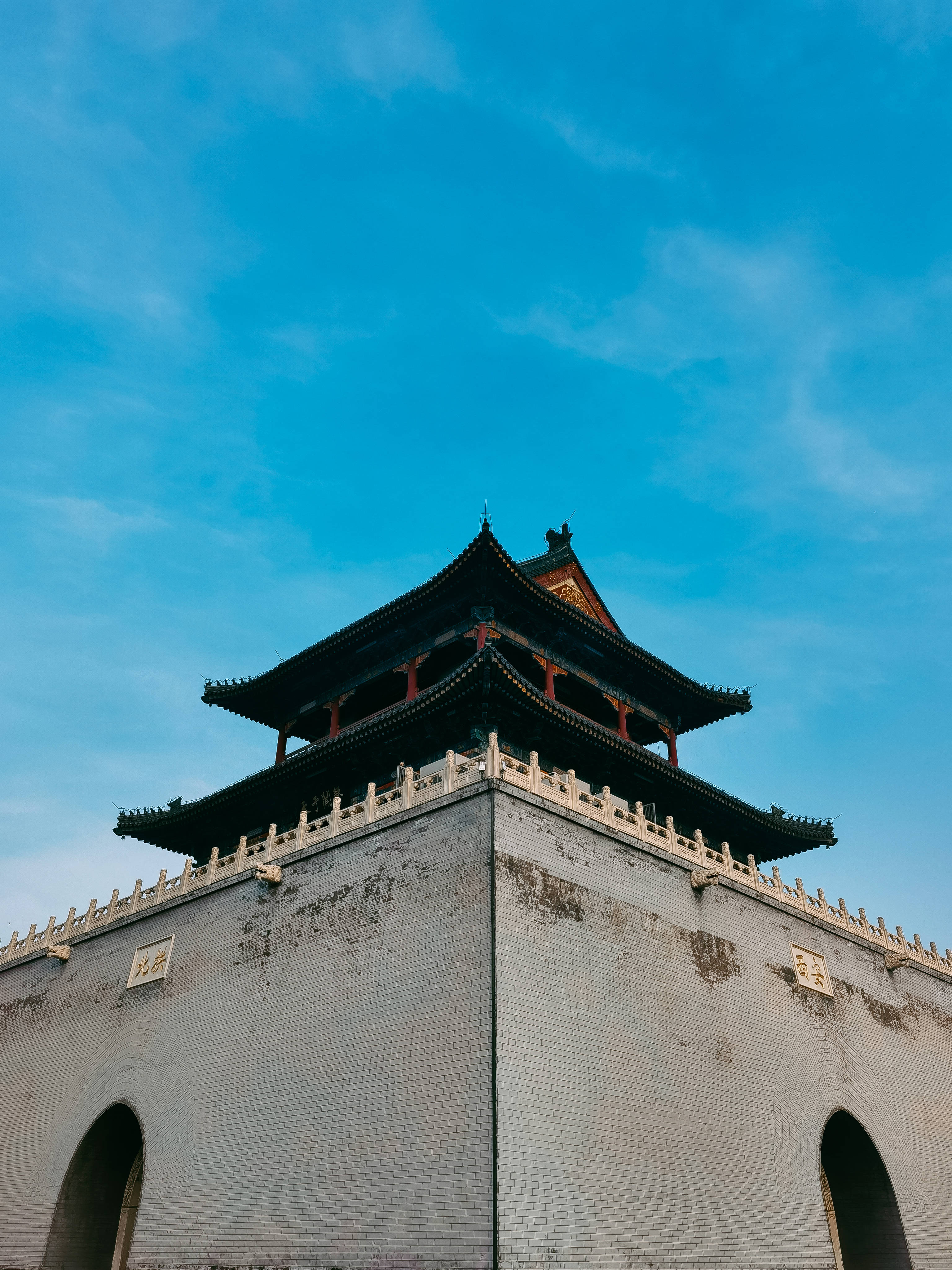 華為榮耀手機壁紙：寶塔與晴空 壁紙 — 低角度觀看傳統中式門樓，彎曲的屋簷襯托著鮮豔的藍天。