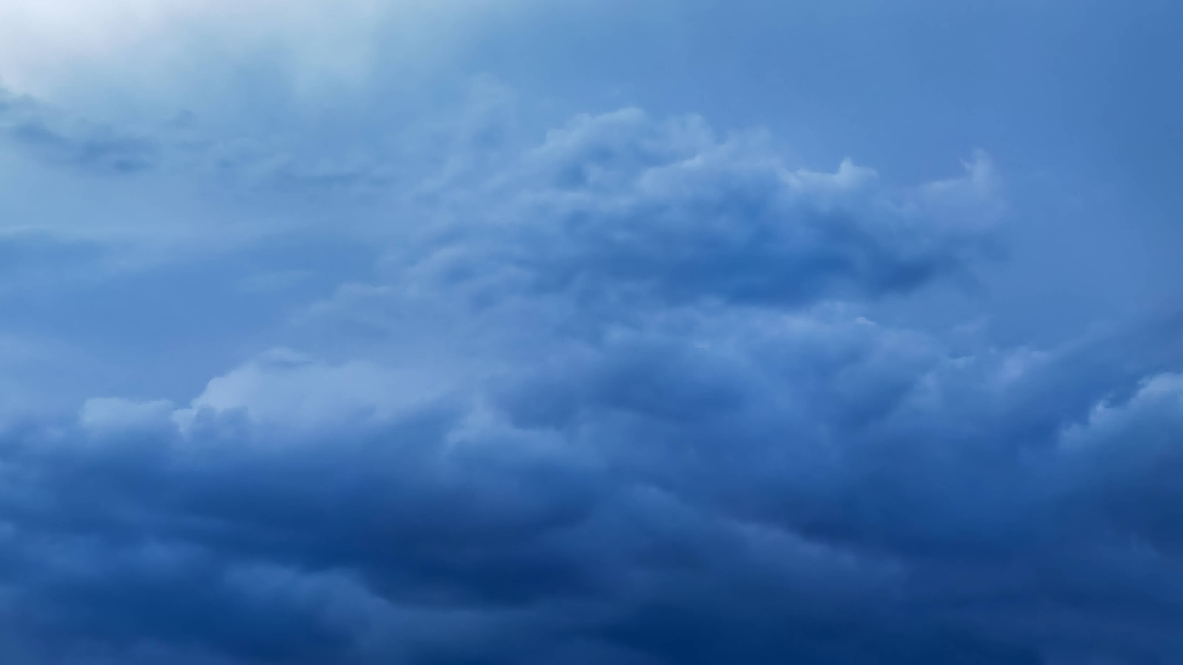 華為榮耀手機壁紙：藍天白雲 壁紙 — 戲劇性的風暴雲在漸暗的暮色天空下以深藍色調旋轉。