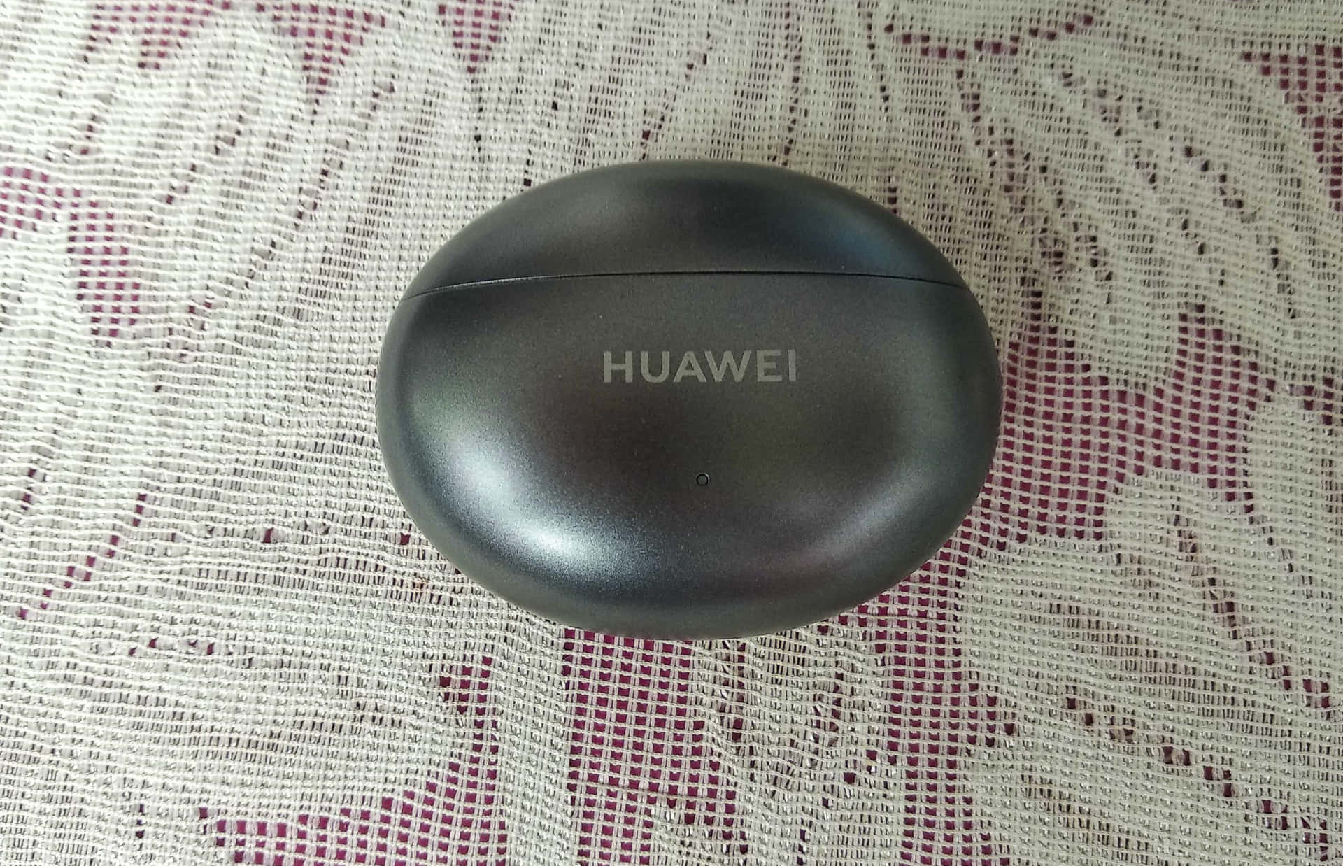 黑色Huawei耳機盒在圖案布料背景上