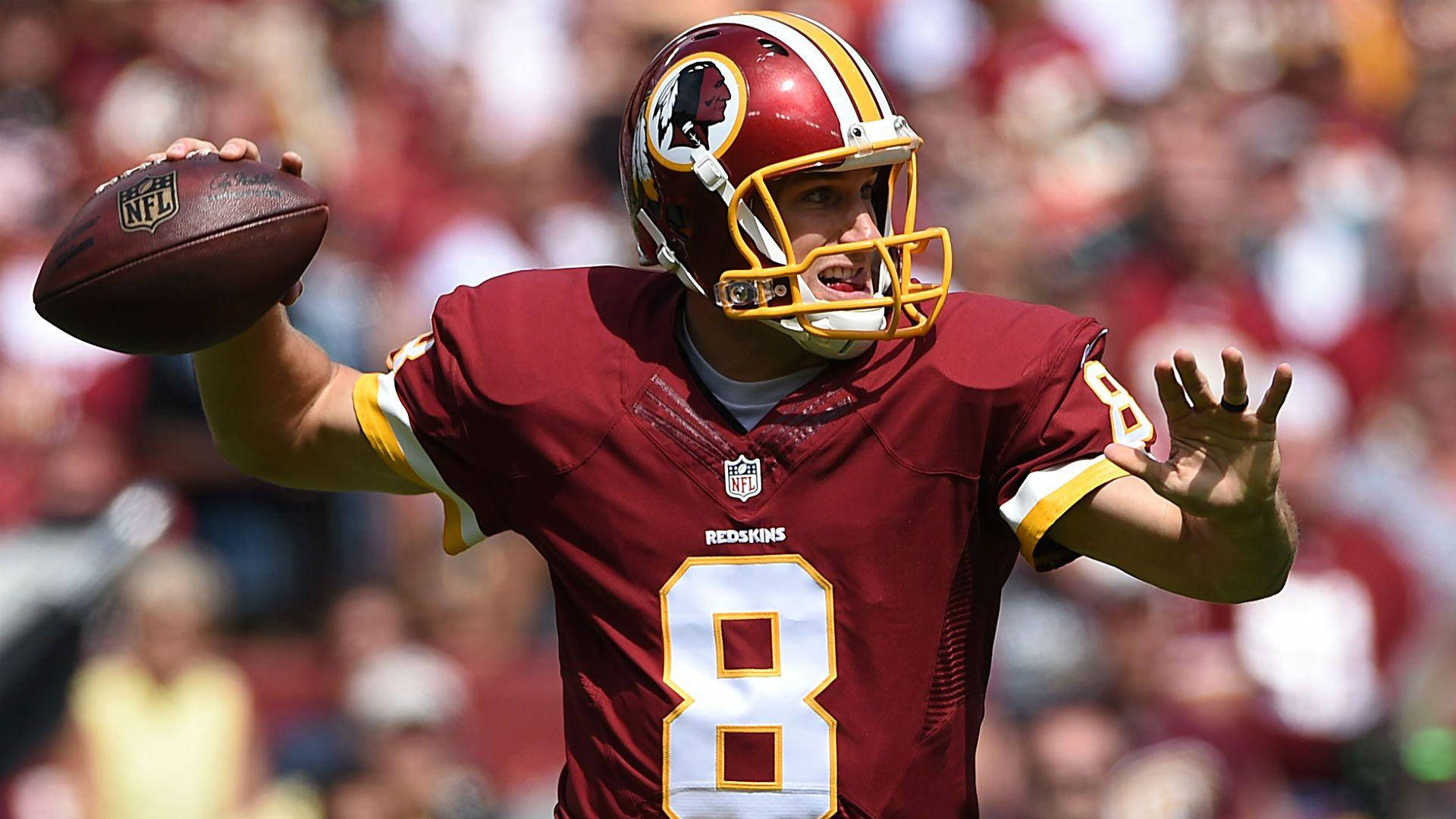 華盛頓紅皮隊 Kirk Cousins 壁紙 — 華盛頓紅皮隊的四分衛身穿栗色8號球衣，在陽光明媚的日間比賽中準備投擲橄欖球。