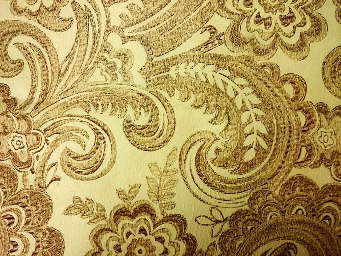Textile Art 桌布 壁紙 — 華麗金色和奶油色佩斯利花紋壁紙的特寫，帶有複雜的花卉和漩渦圖案。