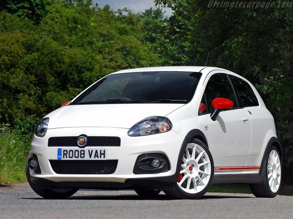 白色Fiat Punto配紅色飾邊停在林蔭大道上。