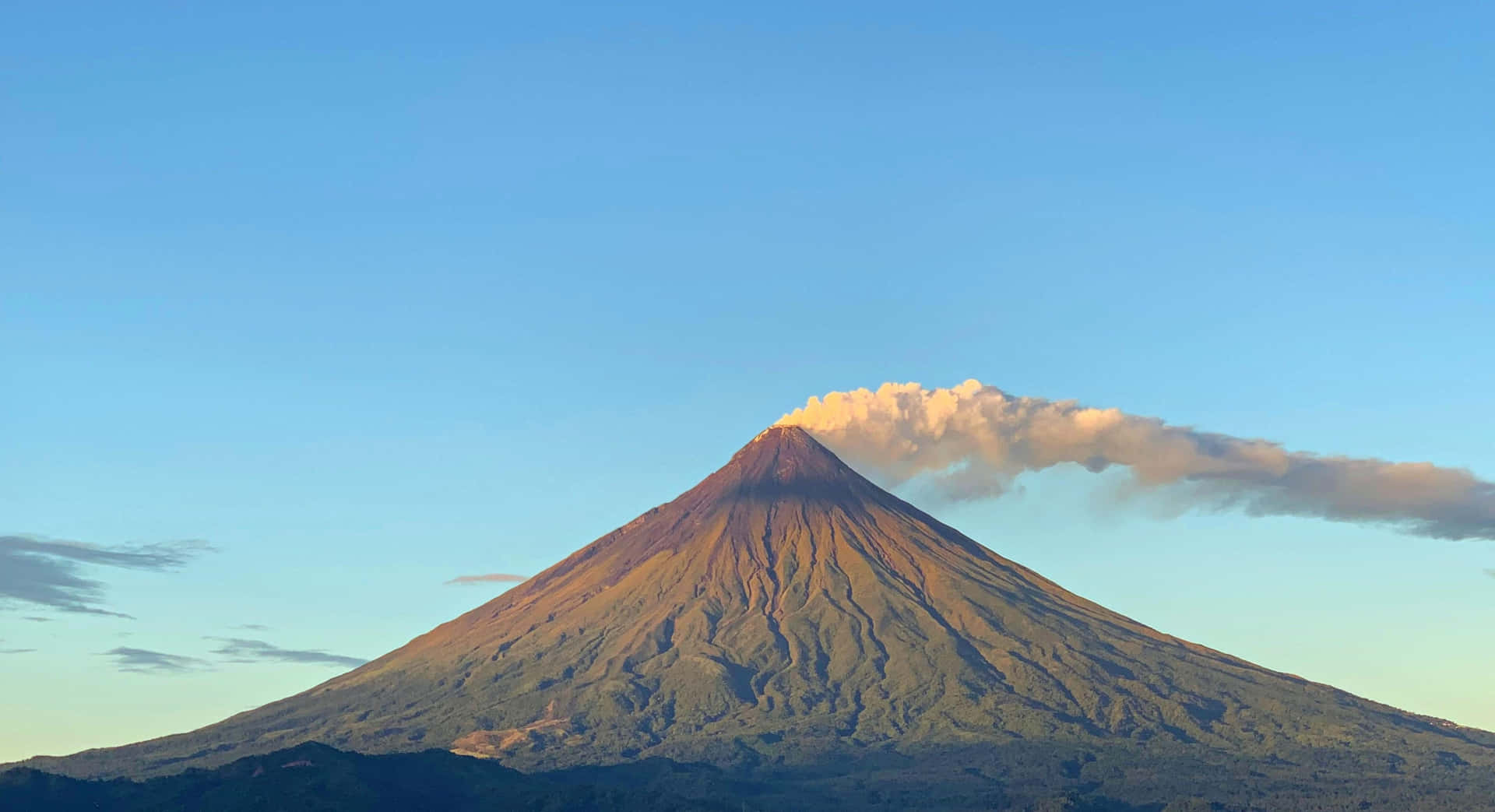 火山在日出中發光，山頂有雲