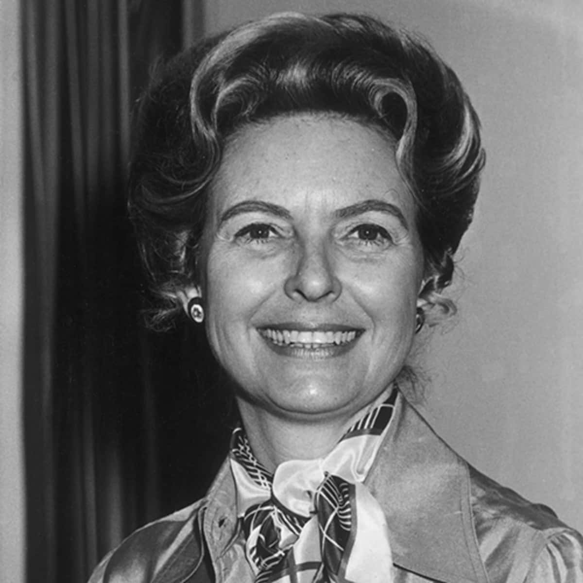 1960年代肖像中，一位面帶微笑的女性戴著圖案圍巾和耳環。