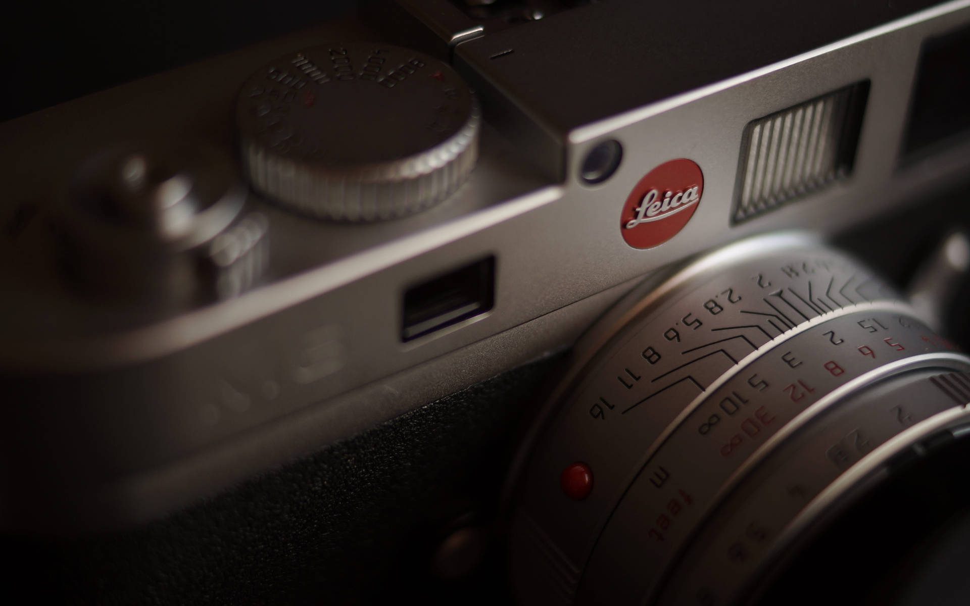 銀色 Leica 相機的特寫，帶有紅色標誌和鏡頭標記。
