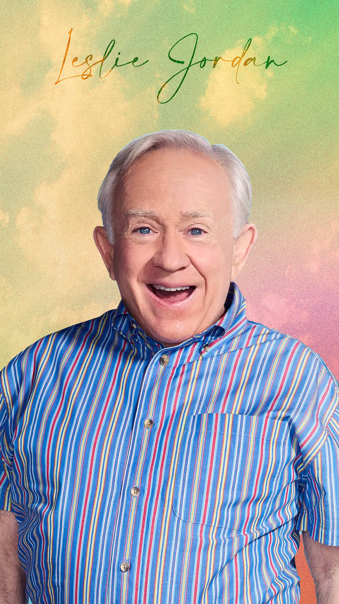Leslie Jordan 身穿彩色條紋襯衫，在柔和漸變背景中微笑。