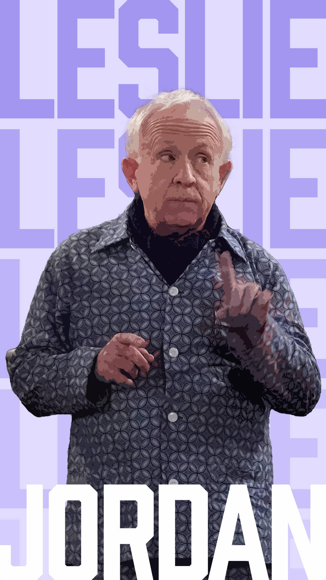 Leslie Jordan 身穿圖案襯衫，背後有文字，做著手勢。