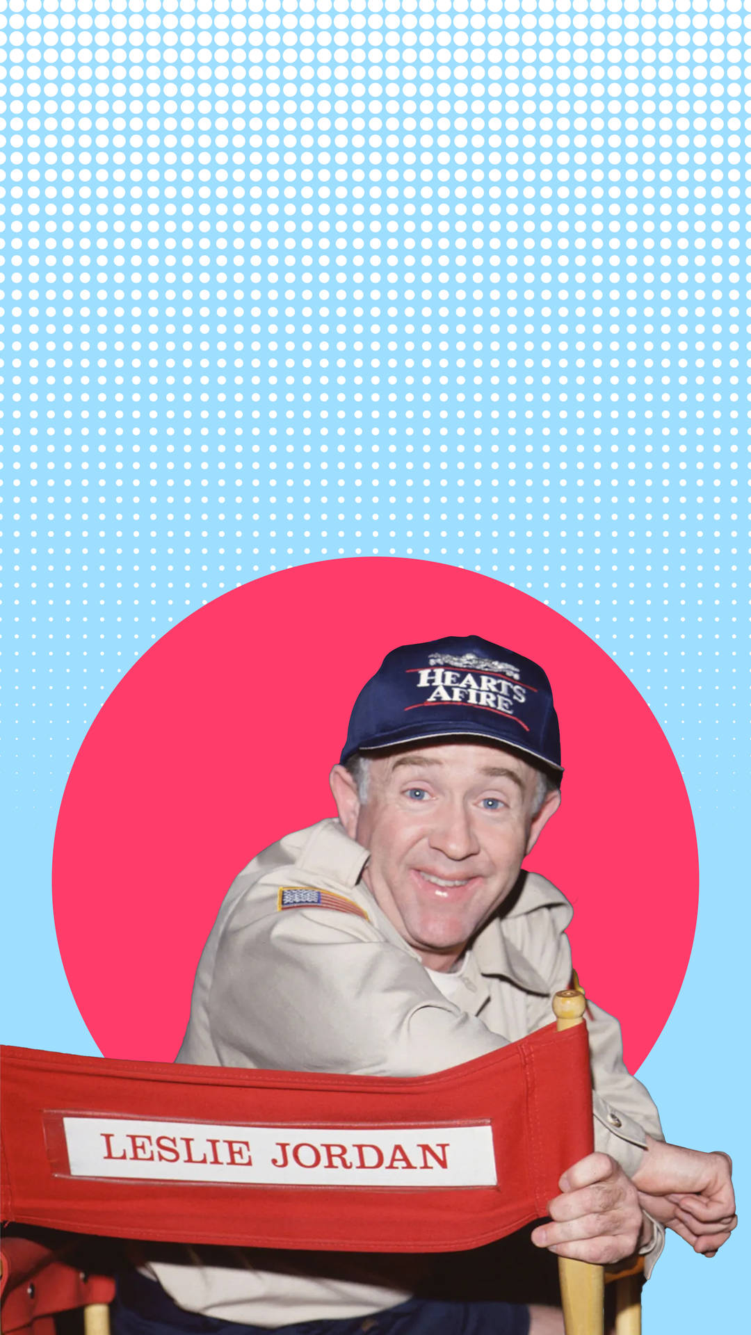 Leslie Jordan 喺導演椅上，背景有粉紅色圓圈同藍色半色調。