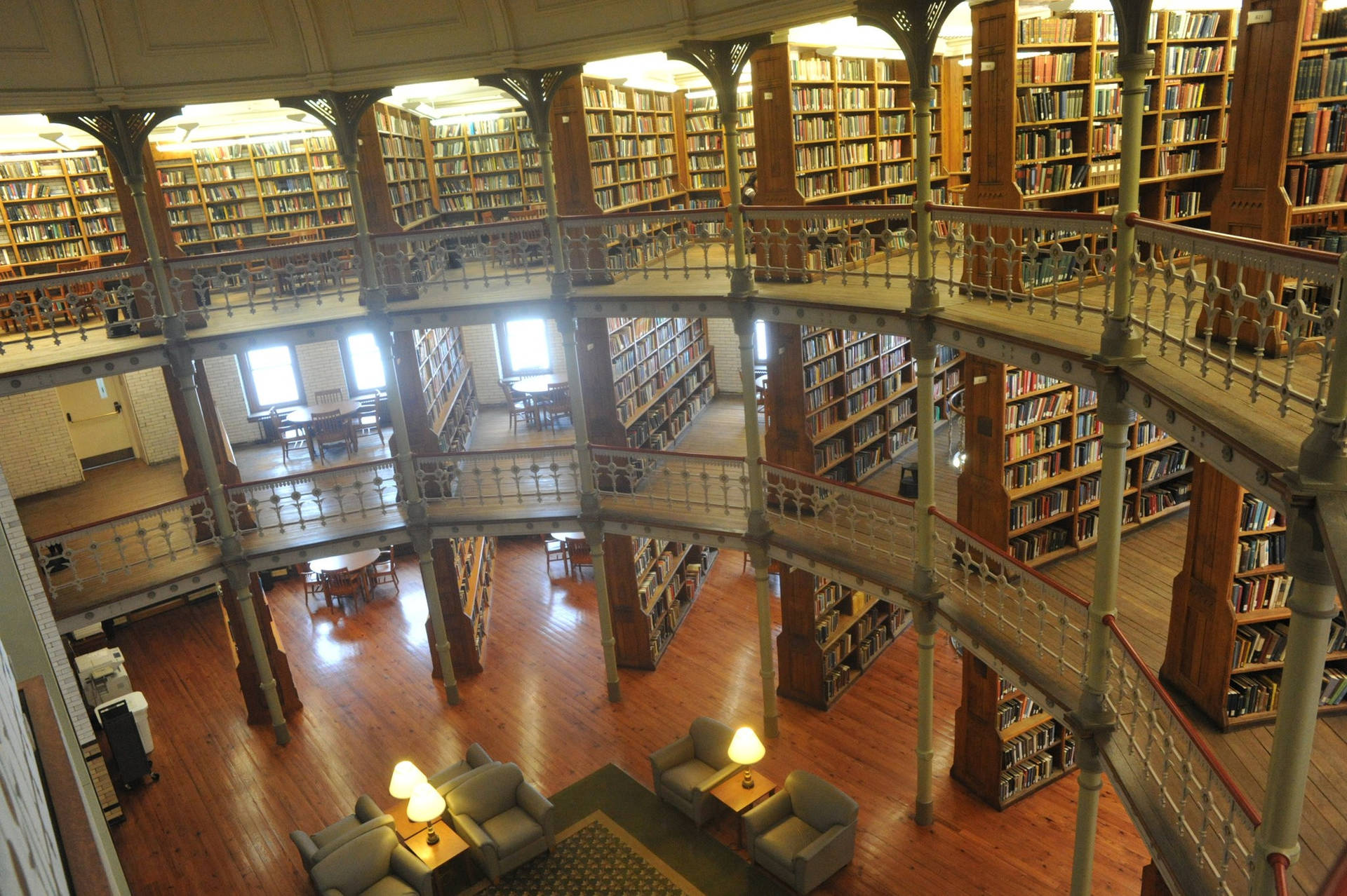 宏偉的多層圖書館，配有木製書架和鐵欄杆。