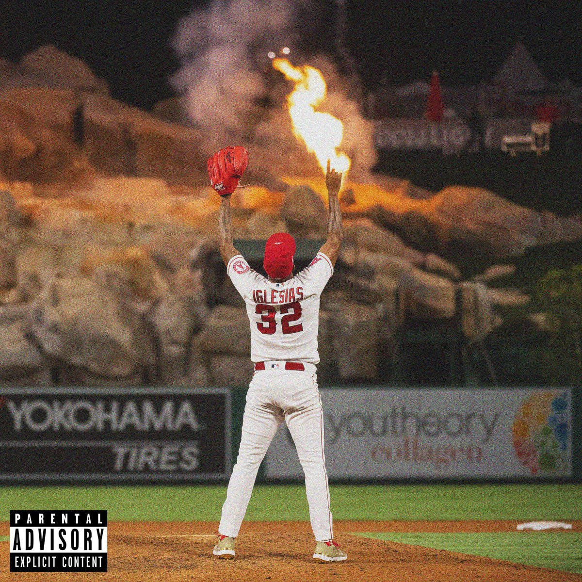 棒球運動員伊格萊西亞斯在夜間燈光球場上與火焰一同慶祝。