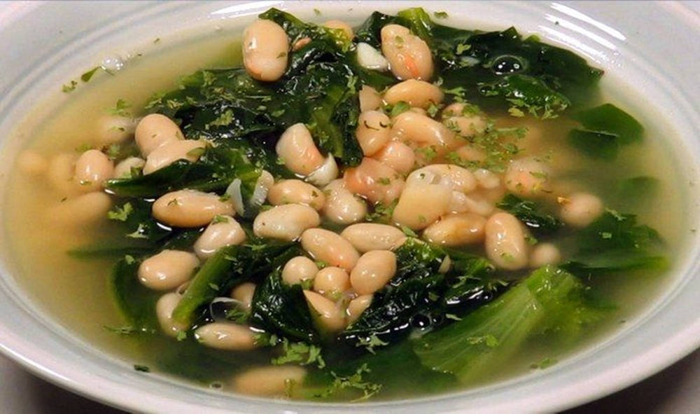 白碗中的白豆綠葉湯。
