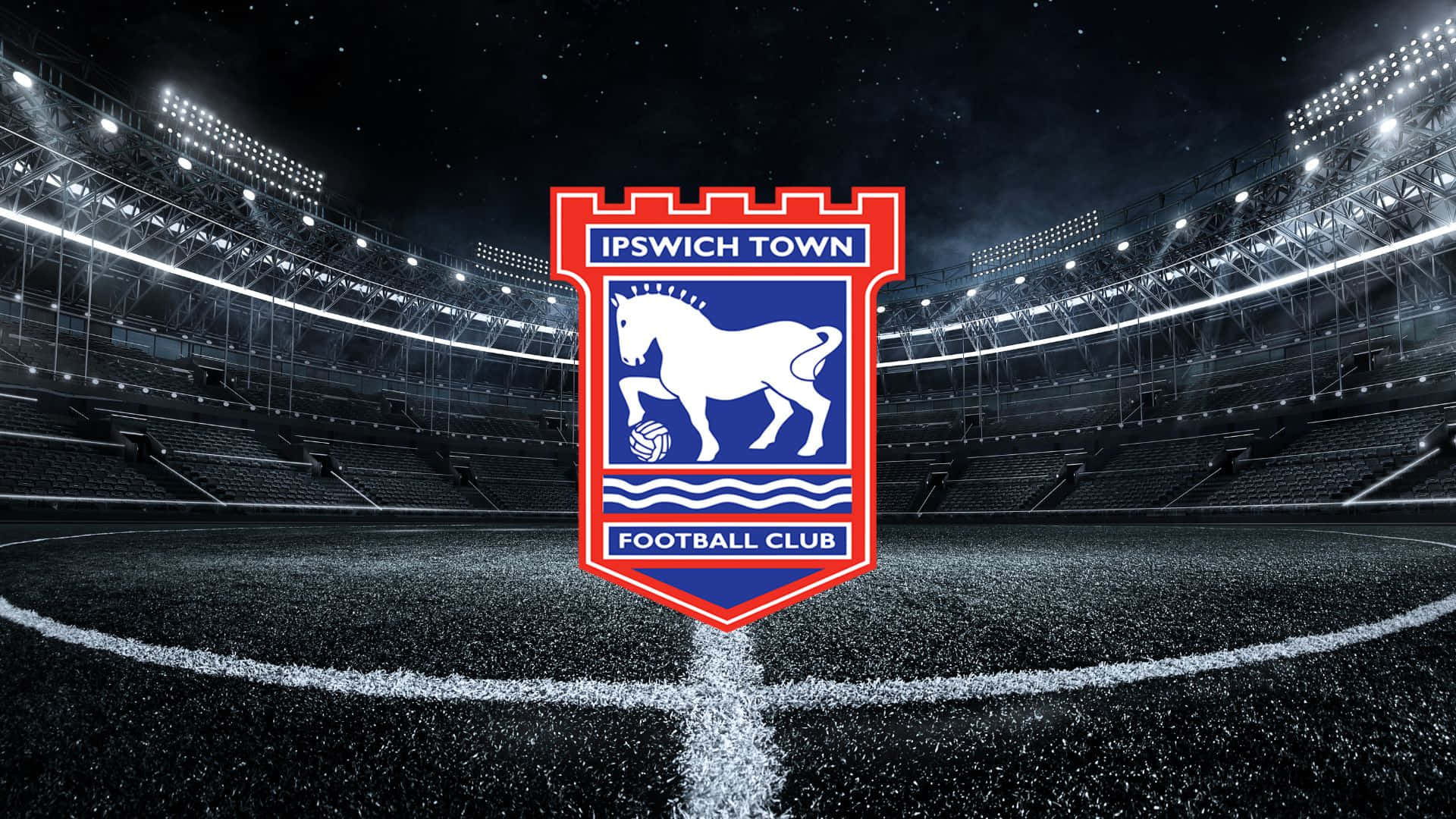 Ipswich Town 桌布 壁紙 — 葉士域治足球會會徽在星空和明亮泛光燈下的空蕩球場中央閃耀。