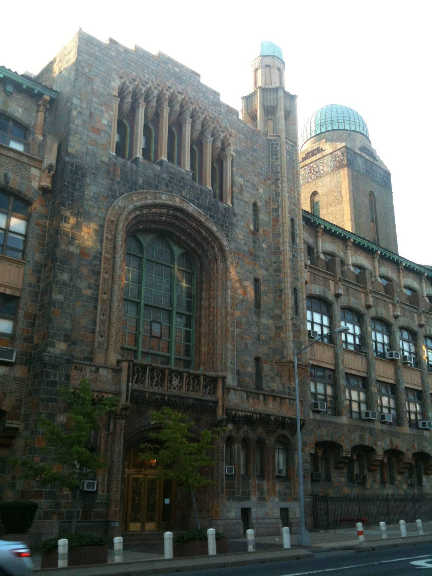 城市街道上帶有拱形窗戶和玻璃圓頂的歷史石建築。
