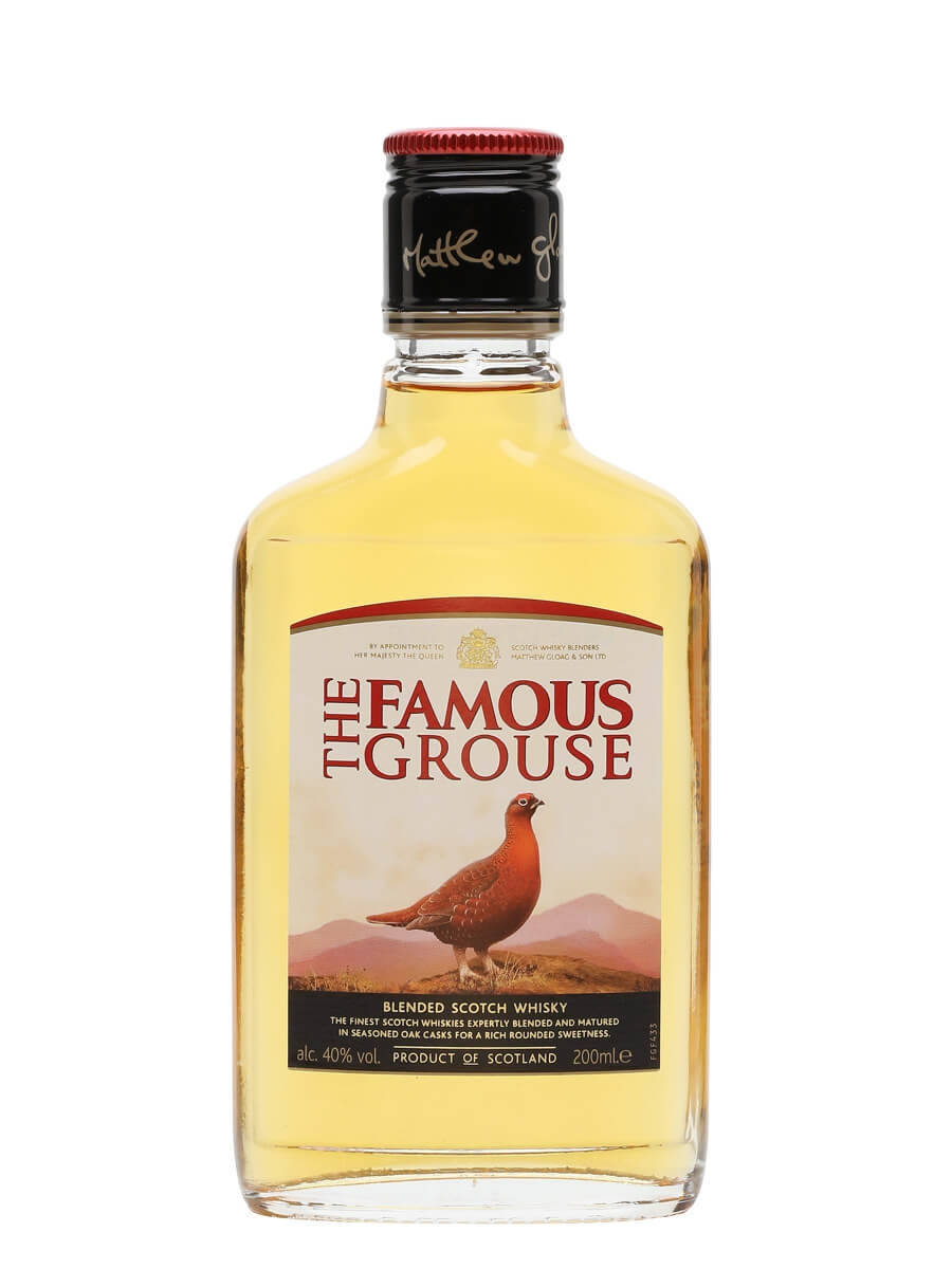 一瓶 The Famous Grouse 威士忌，帶有紅色瓶蓋和標籤，標籤上顯示一隻紅松雞在山脈上。