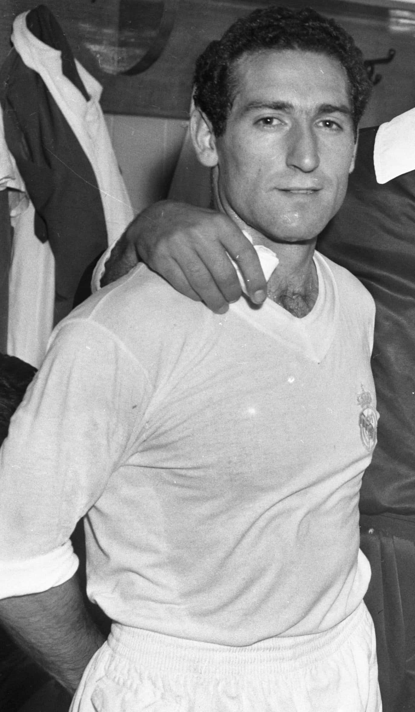 著名西班牙足球員弗朗西斯科·亨托 壁紙 — 一位面帶微笑的足球員身穿皇家馬德里球衣，隊友的手搭在他肩上的黑白肖像。
