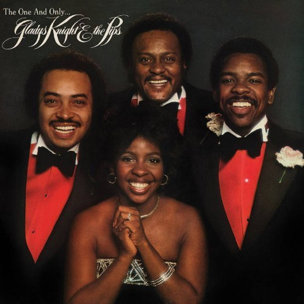 葛萊蒂絲·奈特與The Pips的復古肖像 壁紙 — Gladys Knight & the Pips 穿著正式服裝在深色背景下燦爛微笑的復古工作室肖像。