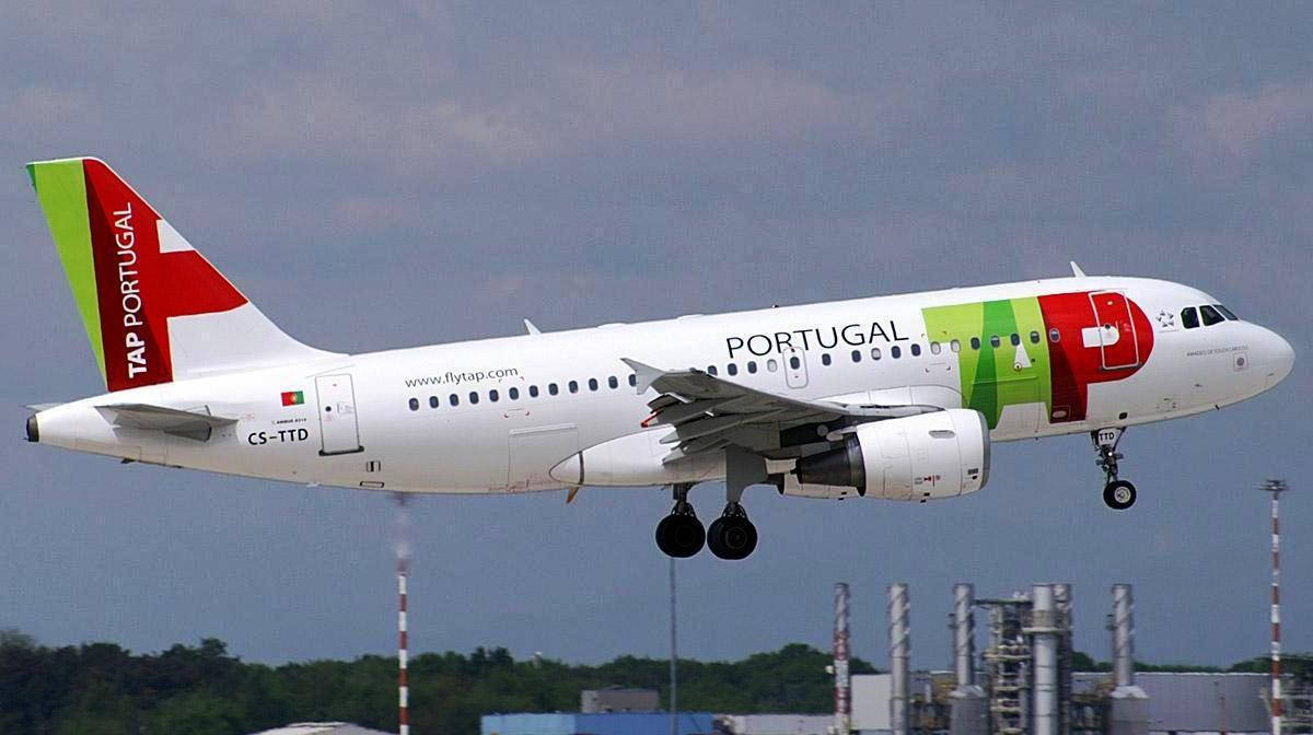 TAP葡萄牙航空飛機放下起落架，在工業建築附近爬升。