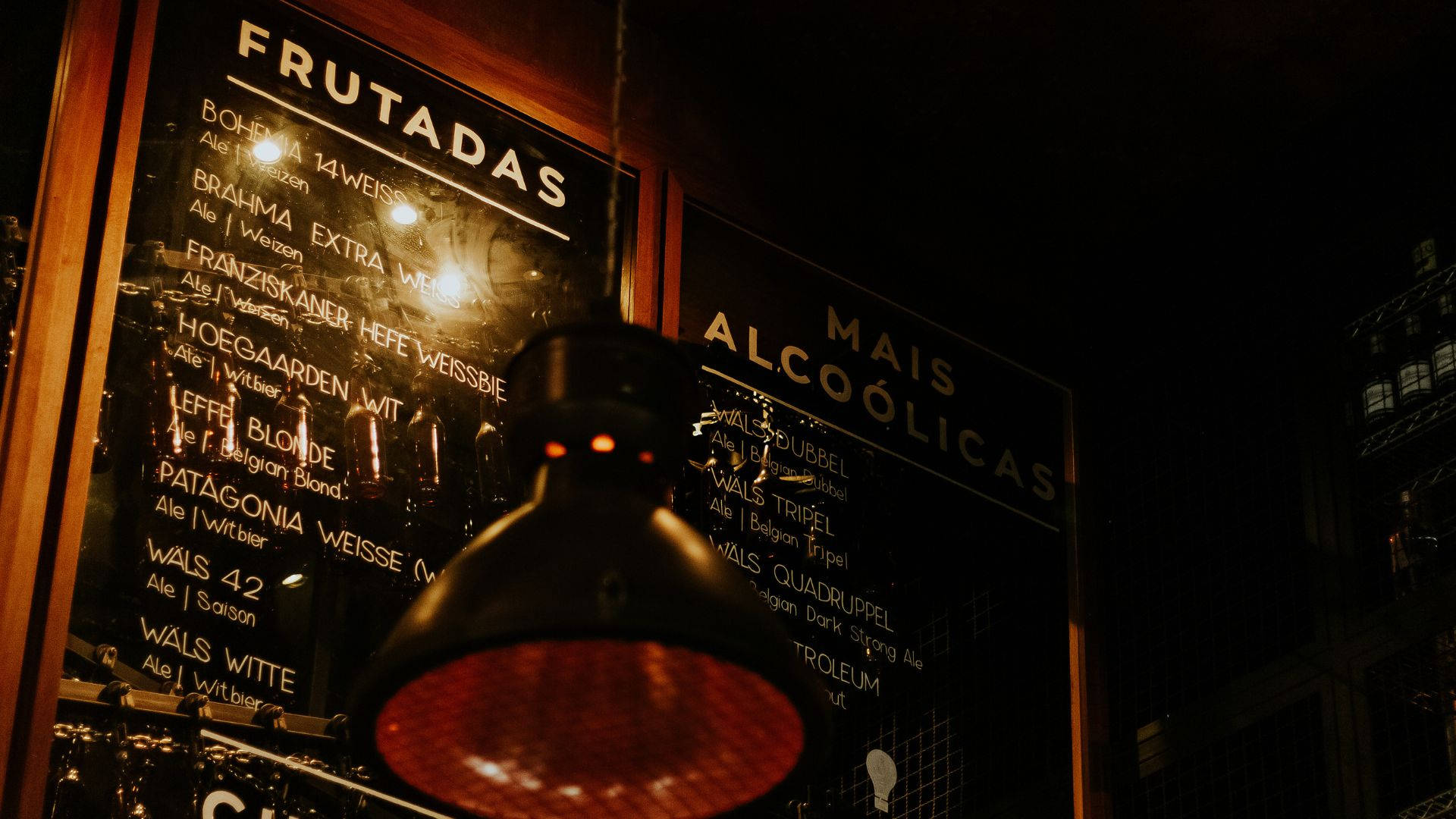 夜間城市酒吧中，復古燈後發光的啤酒菜單板。