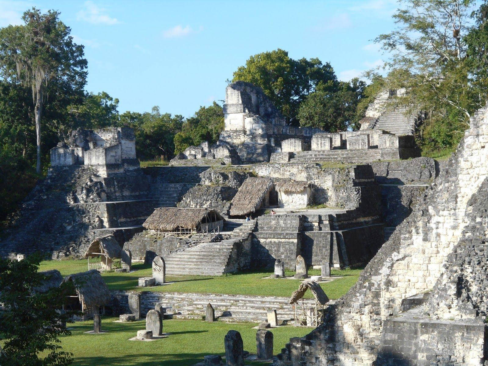 古代瑪雅遺跡，石造建築和茅草屋在熱帶叢林中。