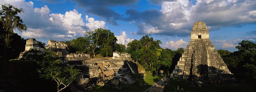 古代瑪雅遺址，石金字塔被茂密叢林環繞，天空多雲。