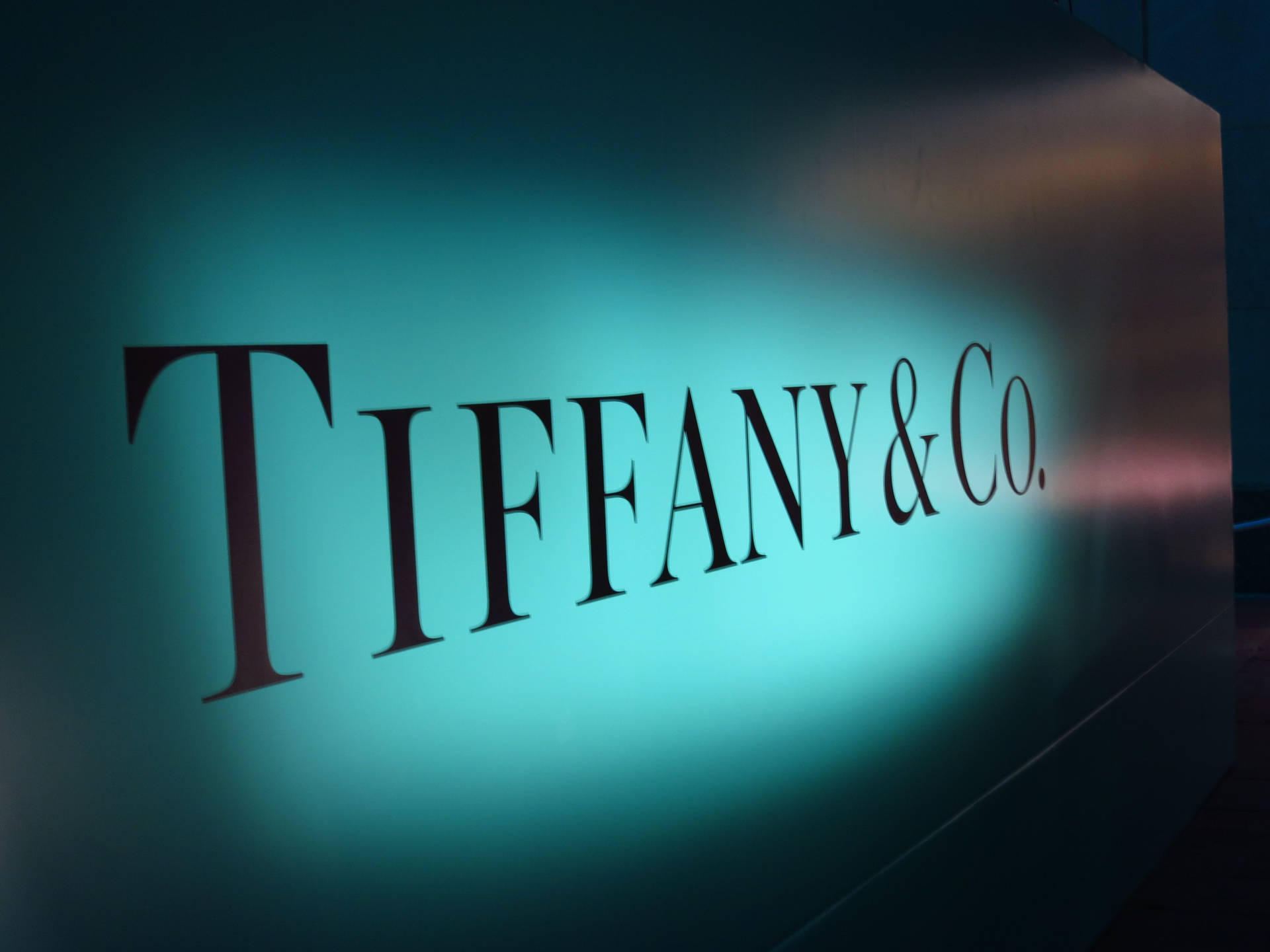 Tiffany & Co.標誌在深色牆壁上發出綠松石色光芒。