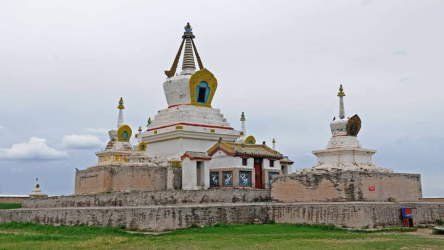 蒙古 Erdene Zuu 寺廟 壁紙 — 古老的白色佛教佛塔帶有金色點綴，莊嚴地矗立在磚砌平台上，天空多雲。