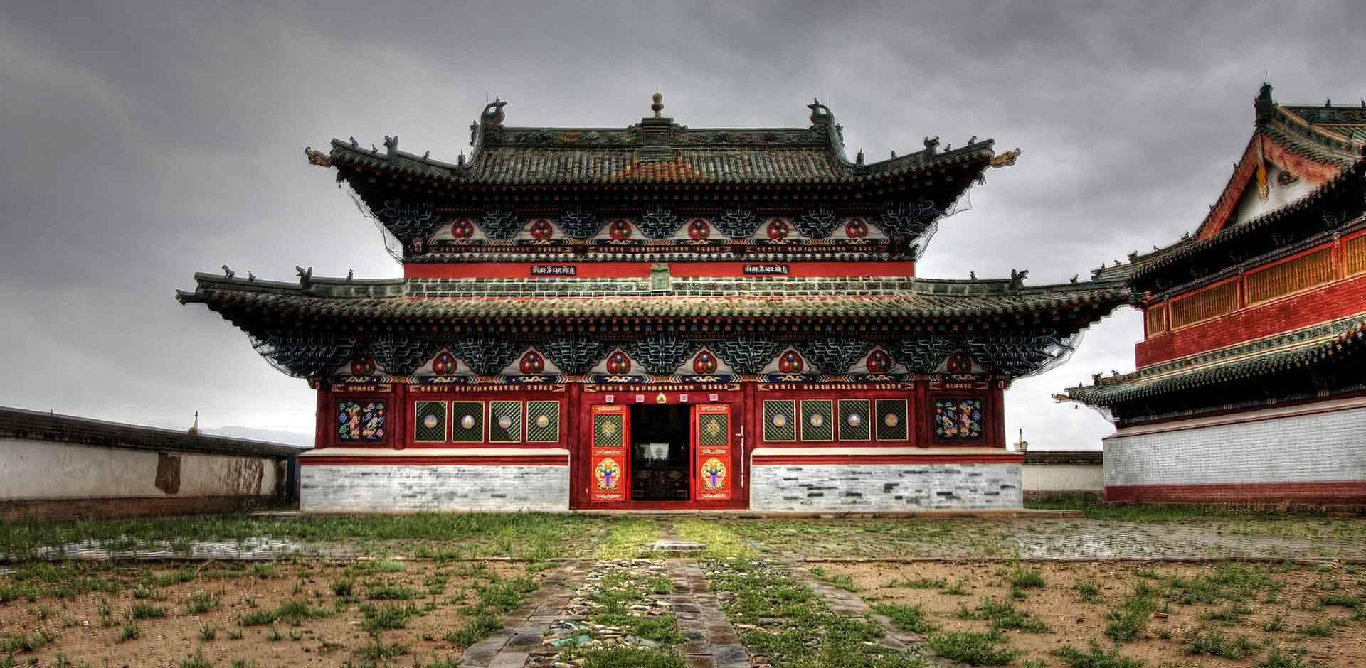 蒙古哈拉和林城 壁紙 — 一座宏偉的傳統中式寺廟，紅牆綠瓦，在沉重的灰色天空下矗立。