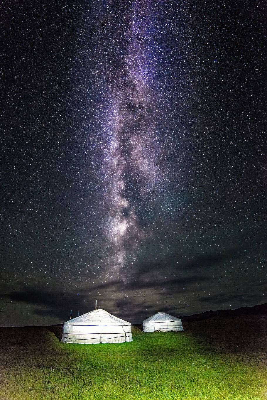 蒙古星空下的帳篷 壁紙 — 兩個白色蒙古包在壯麗星空下閃耀，銀河在草地上方拱起。