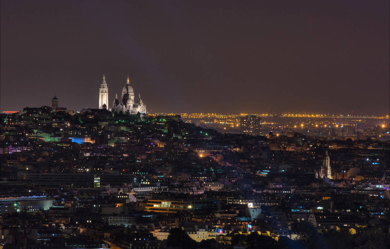 蒙馬特區與聖心大教堂夜景 壁紙 — 巴黎全景夜景，展示蒙馬特山頂上燈火通明的聖心大教堂，俯瞰廣闊的城市景觀。
