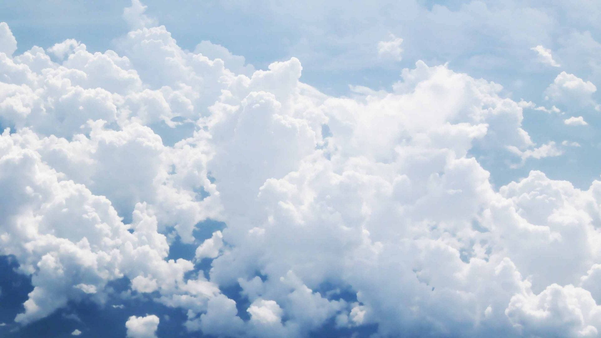 蓬鬆雲天 壁紙 — 廣闊蓬鬆的白雲在明亮的藍天上飄浮，呈現寧靜的白天景象。