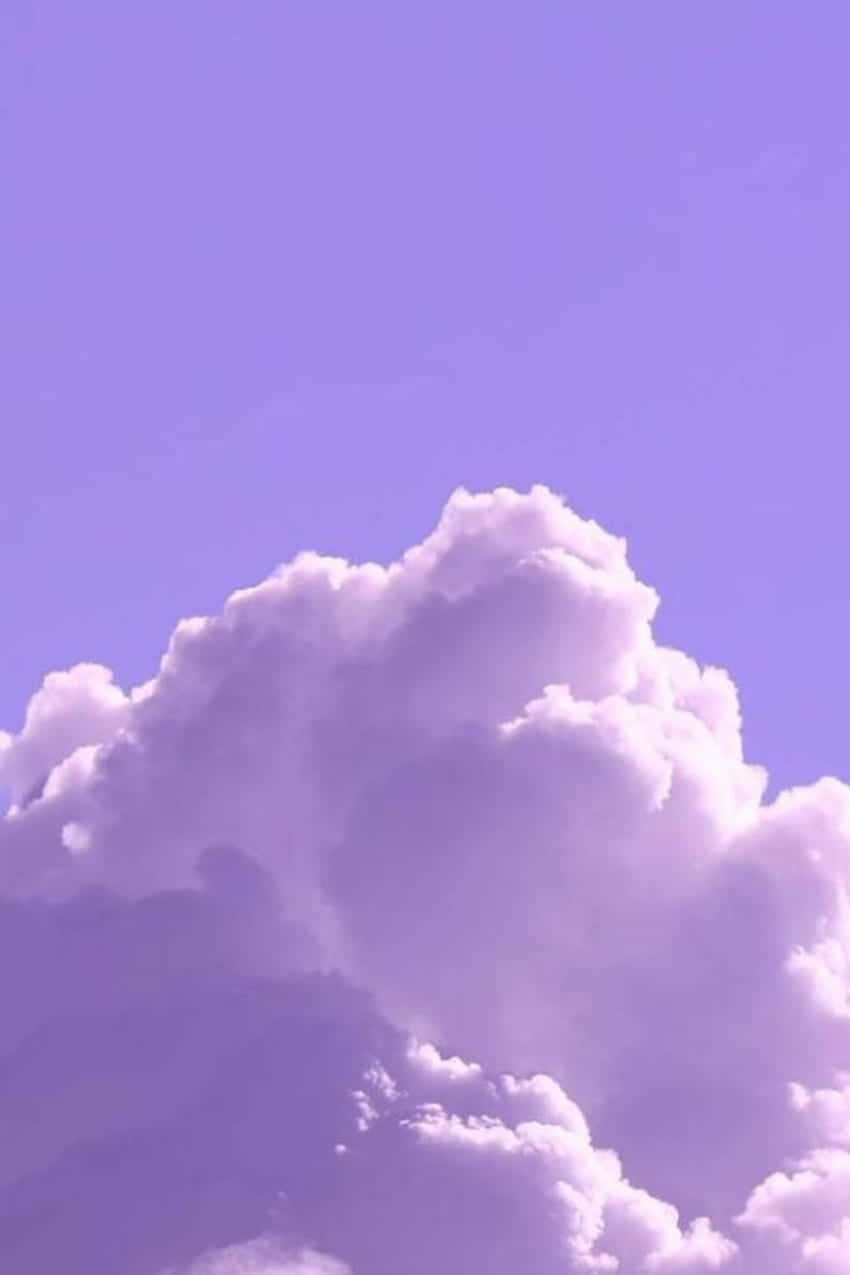 一朵大蓬鬆的白雲映襯著薰衣草色天空