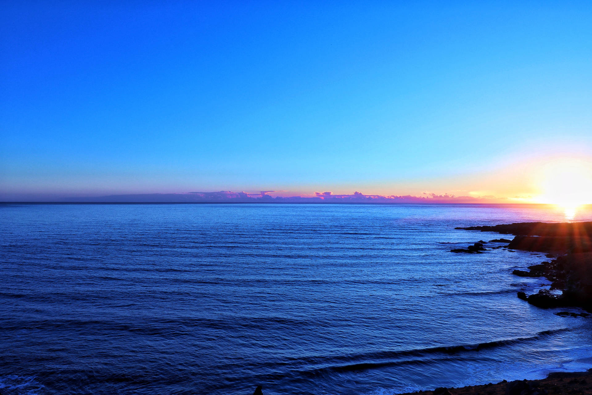 海洋上的夕陽，岩石海岸和鮮豔的天空色彩