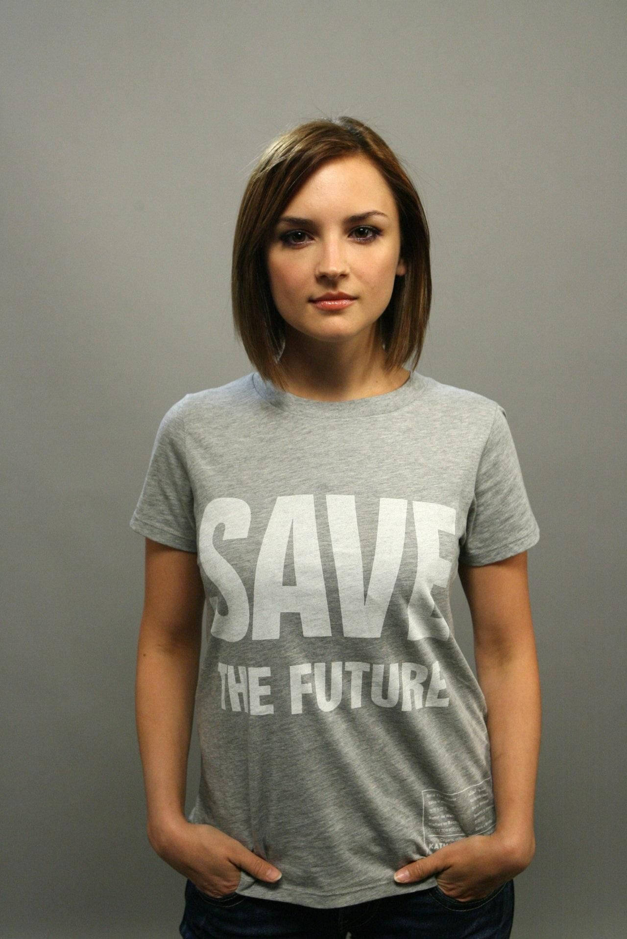 年輕女性穿著灰色T恤，白色文字寫著save the future。