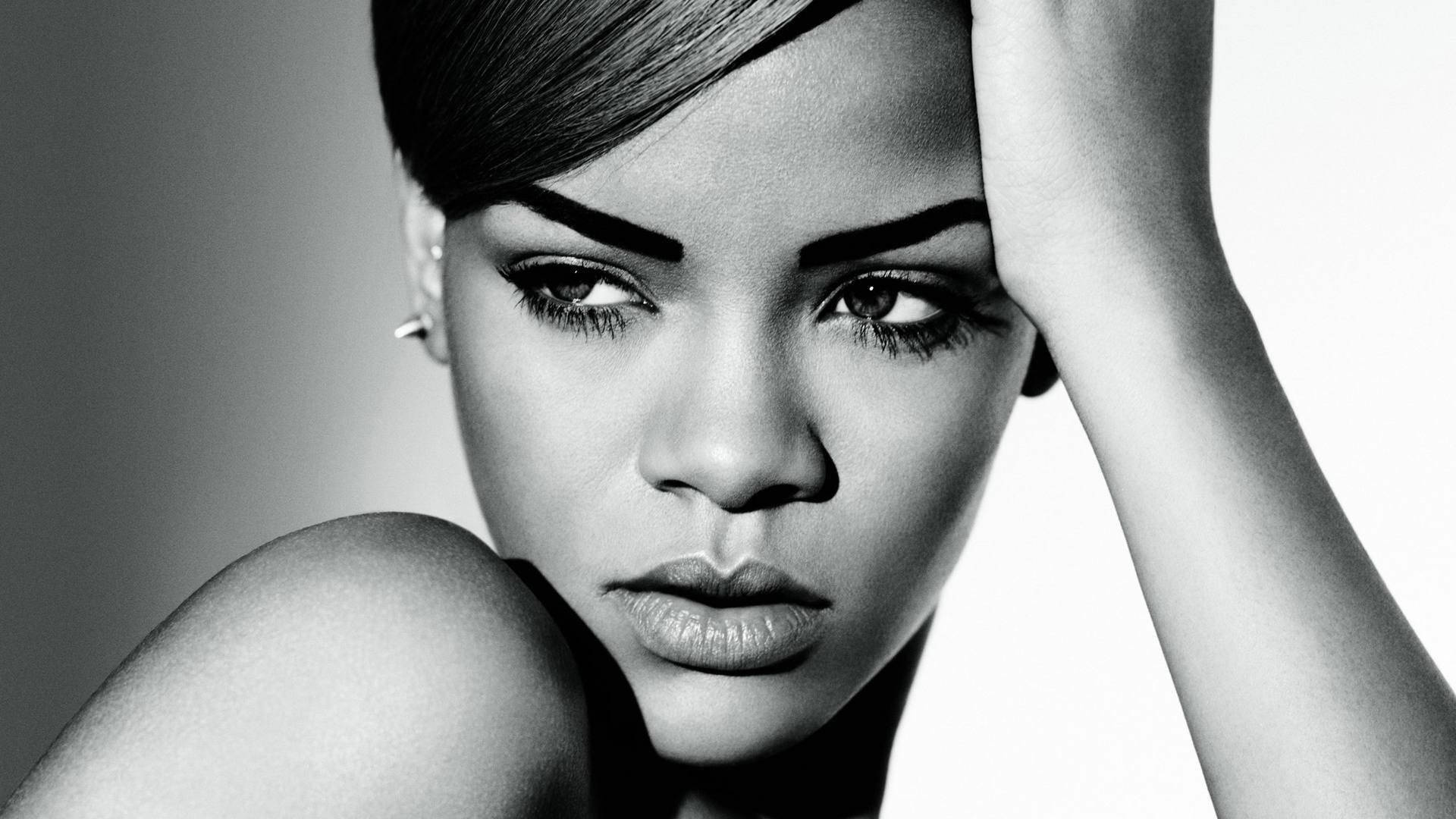 Rihanna 的黑白工作室肖像，手放在頭上。