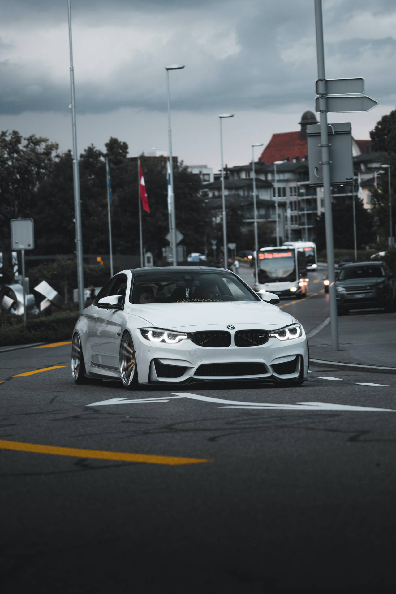 多雲天空下潮濕城市街道上的白色BMW M4雙門轎跑車